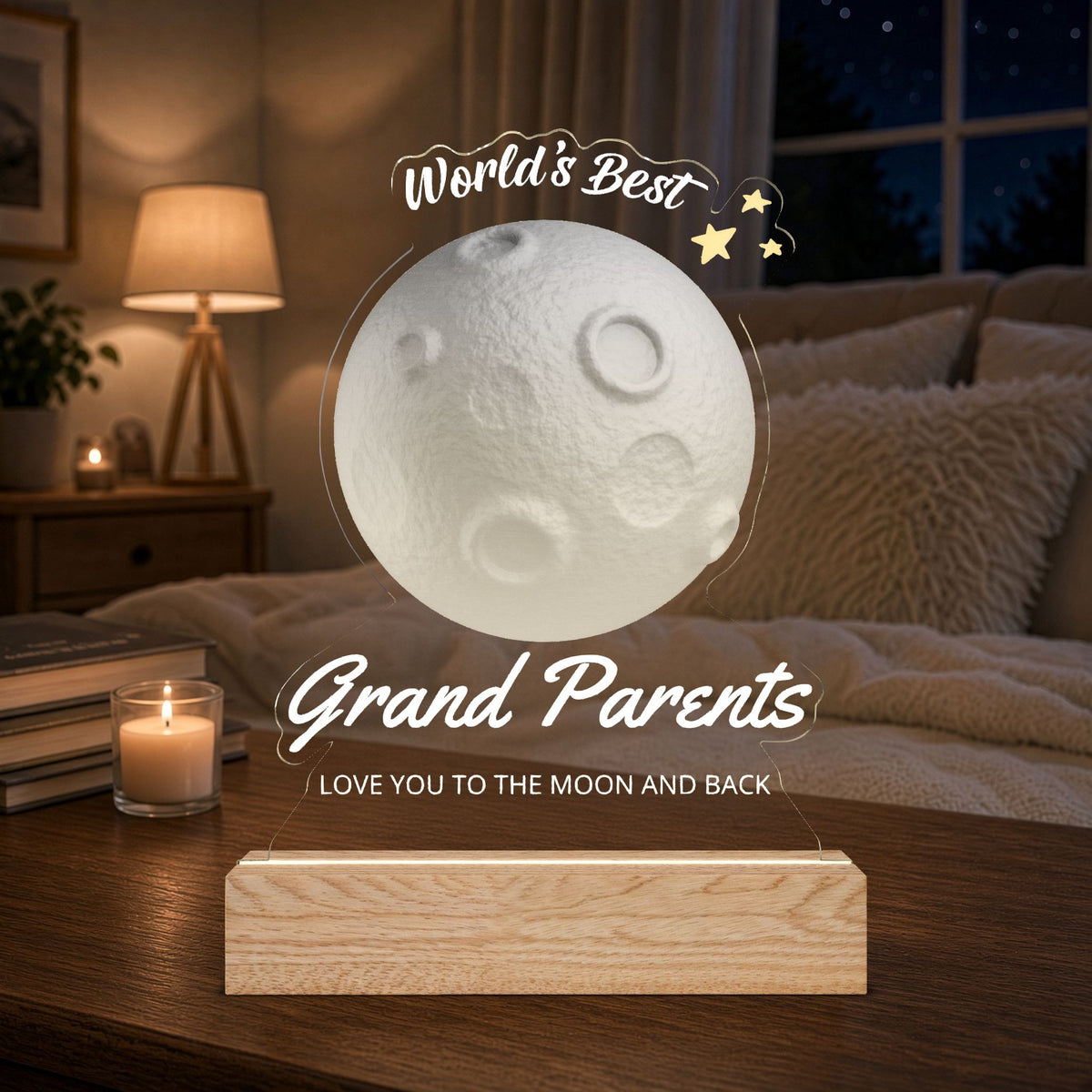 A glowing moon-shaped night light on a wooden base, shown in a cozy bedroom setting with a lit candle, lamp, and bed in the background. The text 'World's Best Grand Parents / LOVE YOU TO THE MOON AND BACK' is overlaid on the image.