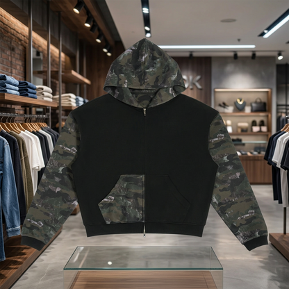 A black zip-up hoodie with camouflage pattern sleeves and a matching camouflage hood lining, displayed flat against a solid white background.
